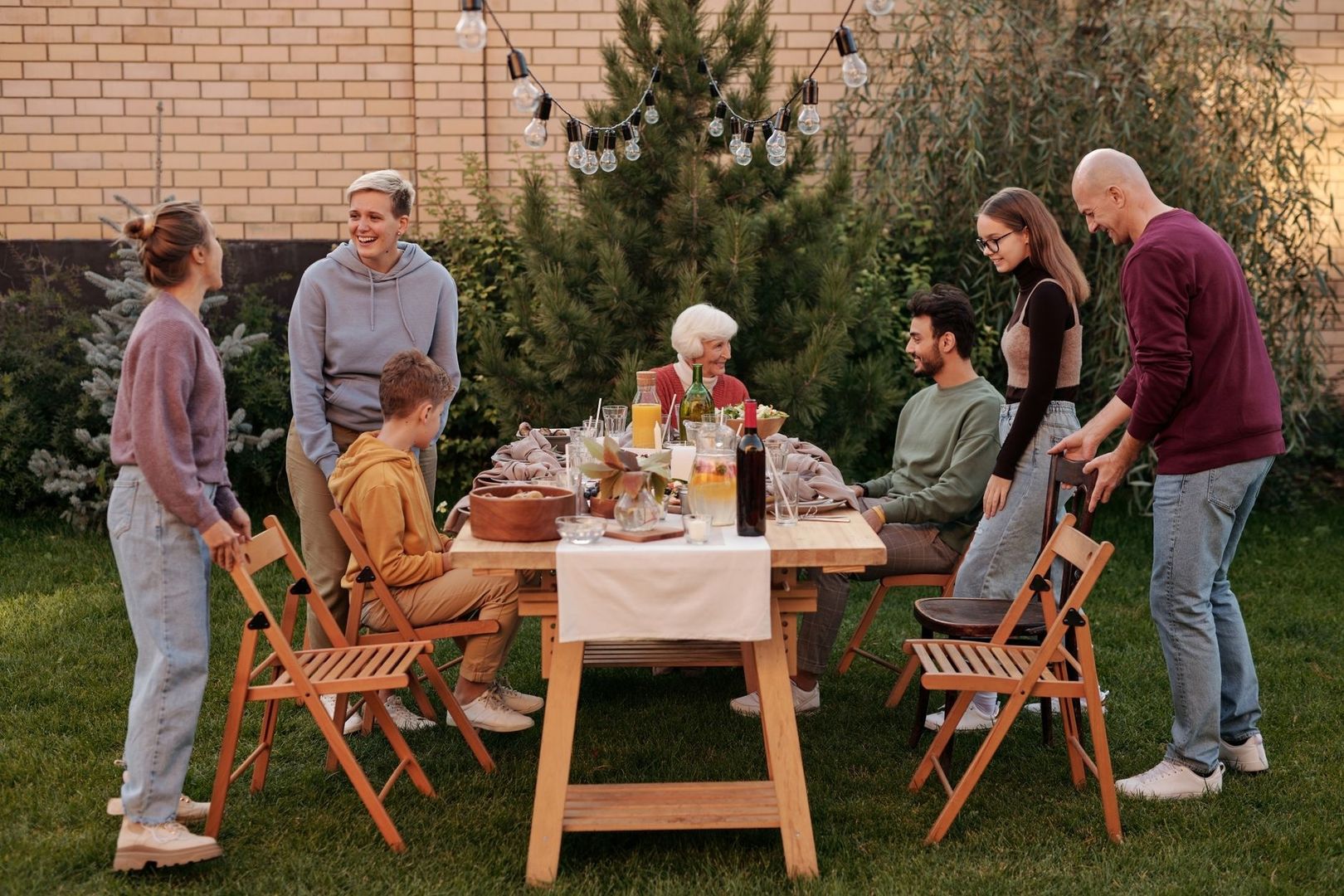 Mehrgenerationenfamilie an gedecktem Gartentisch mit Sitzplätzen