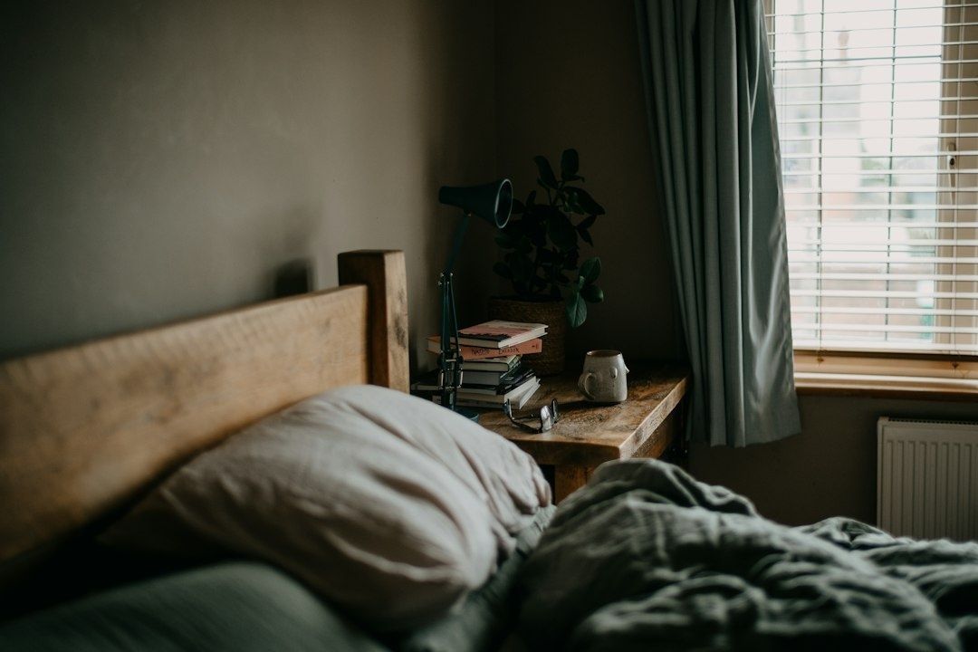 Rustikales Schlafzimmer mit Bett, Vorhängen und hellem Fensterlicht