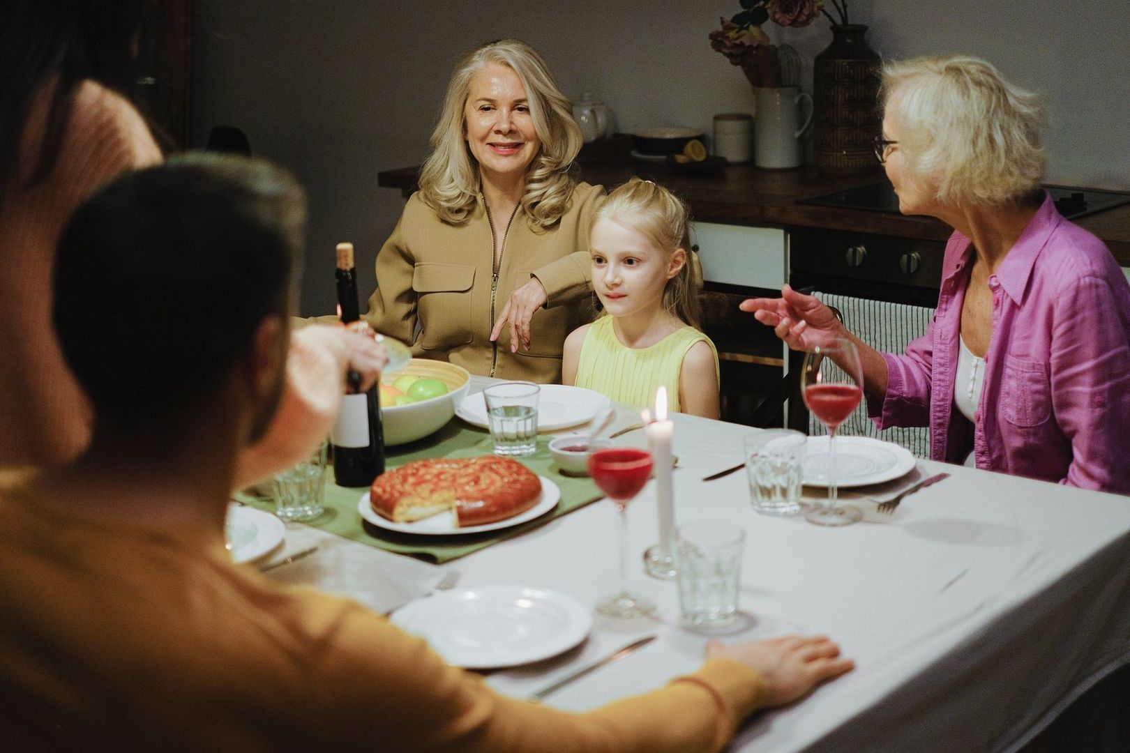 Mehrgenerationen-Familie sitzt bei einem festlichen Essen gemeinsam am Tisch